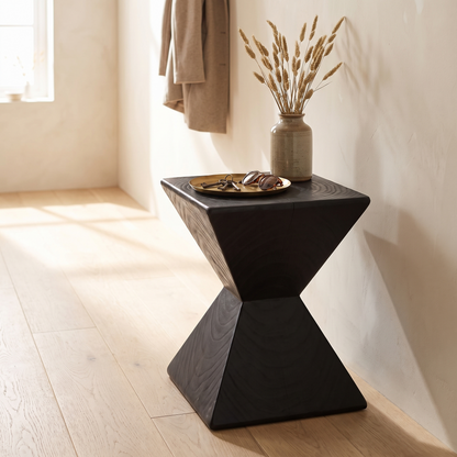 Kaya hourglass side table in a hallway with a brass tray and dried grasses