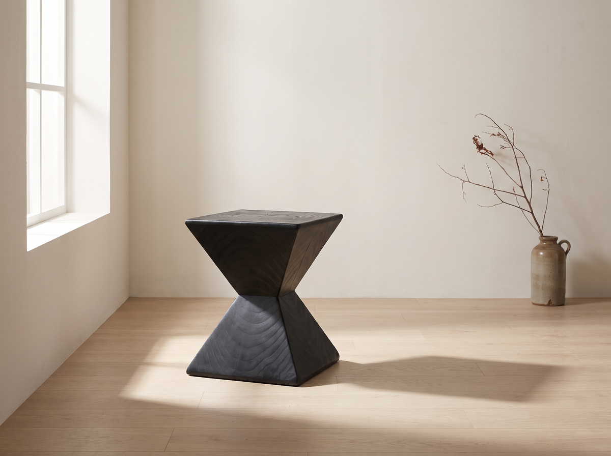 Kaya hourglass side table standing alone in a quiet sunlit corner