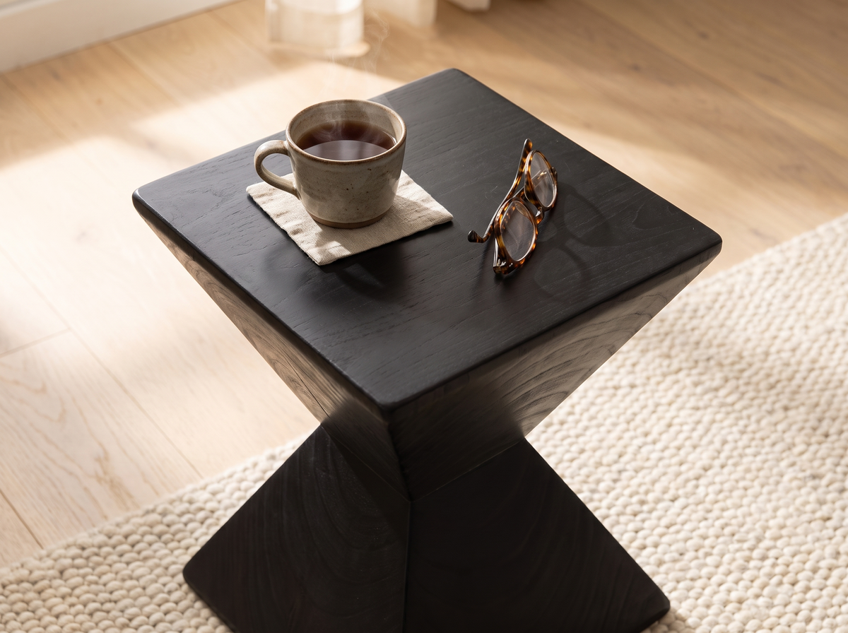 Looking down on the Kaya side table top with a cup of tea and reading glasses