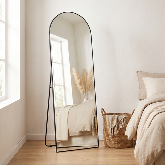 Aria black arched full length mirror leaning in a bedroom