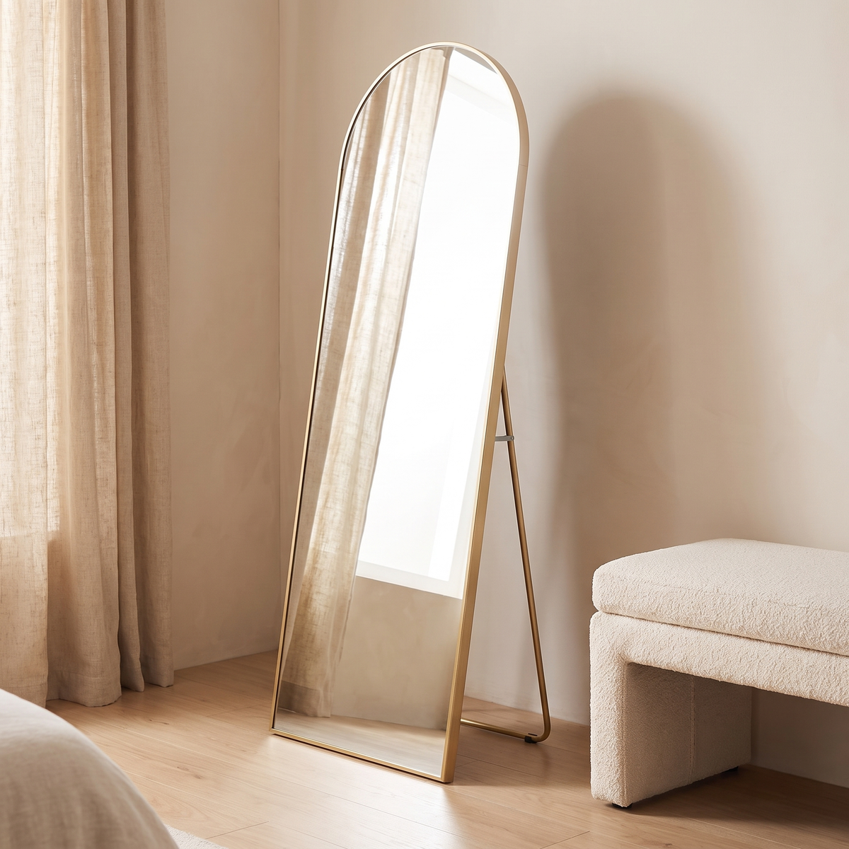 Aria gold arched mirror standing on its back leg