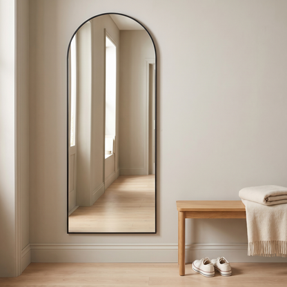 Aria black arched mirror mounted on a hallway wall